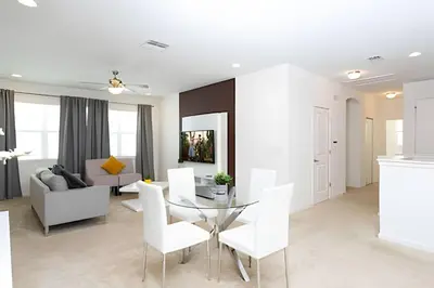 a living room with a glass table and white chairs at Luxuosa Villa 9 Suítes c/ Piscina Sonoma Resort in Kissimmee