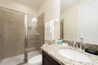 a bathroom with a toilet and a sink and a shower at Luxury 9-Bedroom Villa with Pool Near Disney in Orlando
