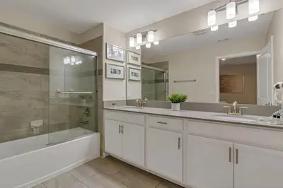 a bathroom with two sinks and a tub and a shower at Casa Disney 5 Quartos c/ Piscina – 13 Pessoas in Kissimmee