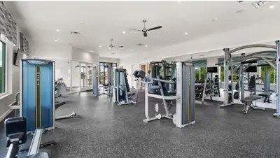 a gym with several tread machines in a room at Casa Disney 5 Quartos c/ Piscina – 13 Pessoas in Kissimmee