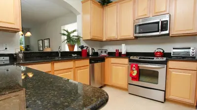 a kitchen with wooden cabinets and stainless steel appliances at Urban 6 Bed 4 Bath Villa- Perfect stay while exploring Orlando,Florida in Orlando