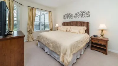 a bedroom with a bed and a tv and windows at Urban 5 Bed 5 Bath Villa- Perfect stay while exploring Orlando,Florida in Orlando