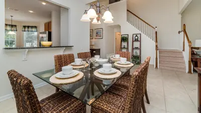 a dining room with a glass table and chairs at Urban 5 Bed 5 Bath Villa- Perfect stay while exploring Orlando,Florida in Orlando