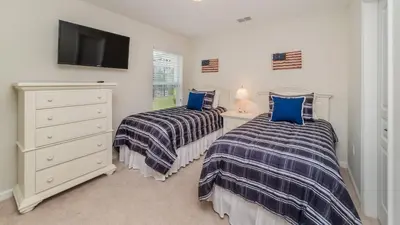 two beds in a room with a tv and a dresser at Urban 5 Bed 5 Bath Villa- Perfect stay while exploring Orlando,Florida in Orlando