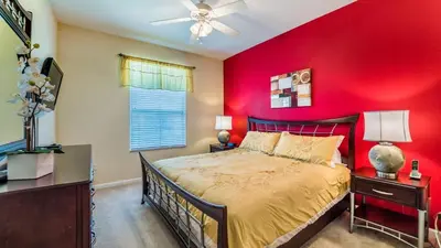 a bedroom with a red wall and a bed at Private 3 Bed 2 Bath House - Cozy family vacation home sleeps up to 6 guests in Orlando