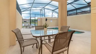a dining room with a glass table and chairs at Private 4 Bed 3 Bath Townhome - Cozy family vacation home sleeps up to 10 guests in Kissimmee