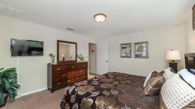 a bedroom with a bed and a flat screen tv at Contemporary 4 Bed 3 Bath Townhome - Near Walt Disney World W/ great amenities in Kissimmee