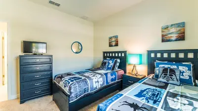 a bedroom with two beds and a tv at GRH9244 - Storey Lake Resort - 5 Bed 4 Baths Townhome in Kissimmee
