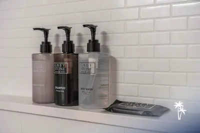 a shelf with four bottles of hair products on it at Boho Chic Garden Condo 7 Min to Universal Parks in Orlando