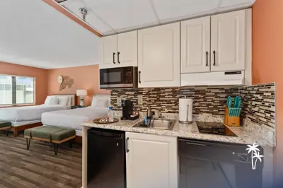 a hotel room with a kitchen and a bed at Boho Chic Garden Condo 7 Min to Universal Parks in Orlando