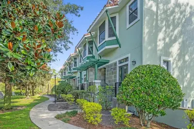 a row of houses with trees and a sidewalk at Florida Summer - Townhome 5 min from Disney in Orlando