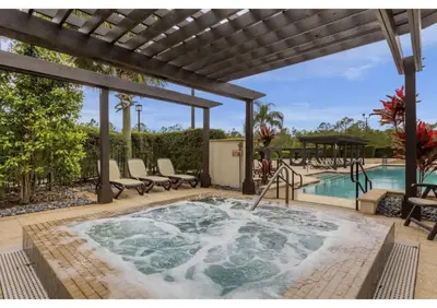a hot tub on a patio next to a swimming pool at Sunny Summer Deals - Renovated TownHome by Disney in Orlando