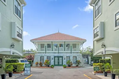 a building with a green door in a parking lot at Sunny Summer Deals - Renovated TownHome by Disney in Orlando