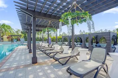 a row of chairs next to a swimming pool at Sunny Summer Deals - Renovated TownHome by Disney in Orlando