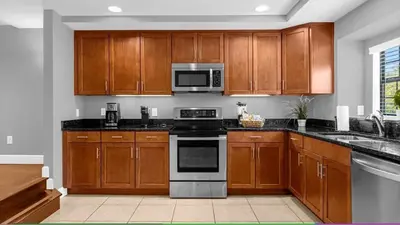 a kitchen with wooden cabinets and a stove top oven at Sunny Summer Deals - Renovated TownHome by Disney in Orlando