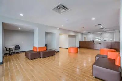 an empty office with orange chairs and desks in a room at Hotel O Orlando Airport near Florida Mall in Orlando