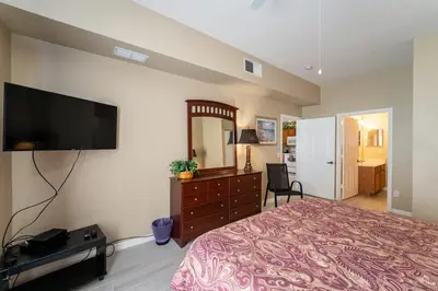 a bedroom with a large bed and a flat screen tv at Resort Bliss Near Disney Longer Stays Welcome in Kissimmee