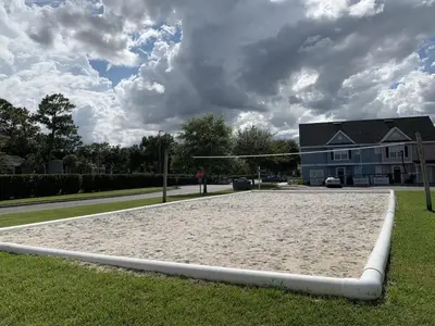a sand volleyball court in front of a house at Resort Bliss Near Disney Longer Stays Welcome in Kissimmee