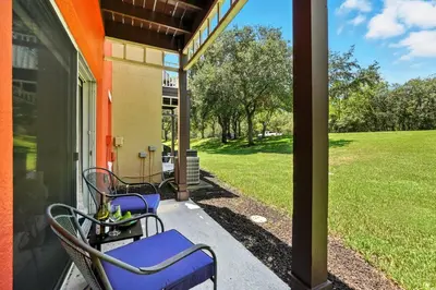 a porch with two chairs and a lawn at Family Getaway Near Clubhouse and Community Pool 5 miles from Disney in Kissimmee