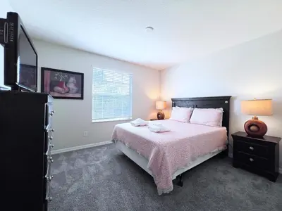 a bedroom with a large bed and a window at Disney Getaway Villa with Private Pool Hot Tub. Book Now VP140 in Kissimmee