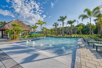 a swimming pool at a resort with palm trees at Disney Getaway Private Pool Themed Bedrooms. Book Now SLR1243 in Kissimmee