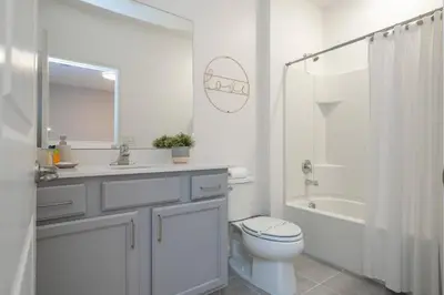 a white bathroom with a toilet and a sink at Disney Private Pool Game Room Themed Bedrooms. Book Now PG20 in Orlando
