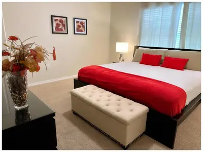 a bedroom with a bed with red sheets and a vase of flowers at Disney Getaway Townhouse with Private Pool. Book Now SLR484 in Kissimmee