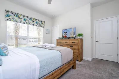 a bedroom with a bed and a dresser and a window at Disney Getaway Private Pool Themed Bedrooms. Book Now SLR410 in Kissimmee