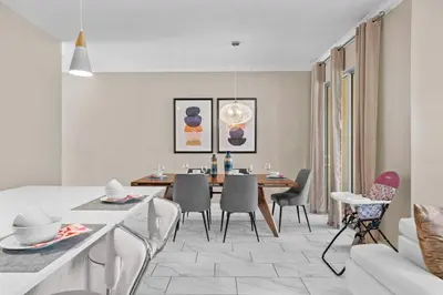 a dining room and living room with a table and chairs at Disney Getaway Private Pool Themed Bedrooms. Book Now SLR411 in Kissimmee