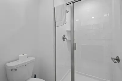 a bathroom with a toilet and a glass shower at Disney Getaway Private Pool Themed Bedrooms. Book Now SLR411 in Kissimmee