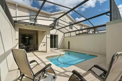 a patio with chairs and a swimming pool at Disney Getaway Townhouse with Private Pool. Book Now SLR476 in Kissimmee