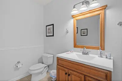 a bathroom with a sink and a toilet and a mirror at Disney Getaway Townhouse with Private Pool. Book Now VC304 in Orlando