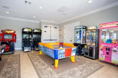 a room with four arcade games and a table in front of them at Disney Getaway Townhouse with Private Pool. Book Now VC304 in Orlando