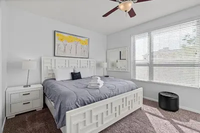 a white bedroom with a bed and a ceiling fan at Disney Getaway Townhouse with Private Pool. Book Now VC304 in Orlando