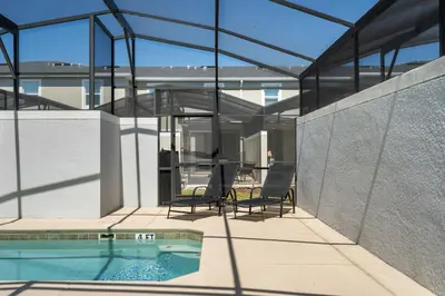 a glass house with a swimming pool and two chairs at Disney Getaway Private Pool Themed Bedrooms. Book Now SLR481 in Kissimmee