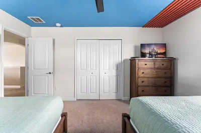 a bedroom with two beds and a dresser with a blue ceiling at Disney Private Pool Hot Tub Game Room Themed Bedrooms. Book Now SLR497 in Kissimmee