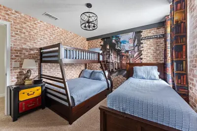 a bedroom with a bunk bed and a brick wall at Disney Private Pool Hot Tub Game Room Themed Bedrooms. Book Now SLR497 in Kissimmee