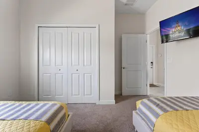 a bedroom with two beds and a tv on the wall at Disney Getaway Private Pool Themed Bedrooms. Book Now SLR503 in Kissimmee
