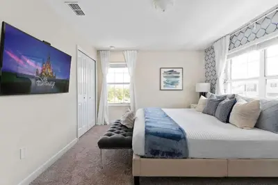 a white bedroom with a large bed and a window at Disney Getaway Private Pool Themed Bedrooms. Book Now SLR503 in Kissimmee