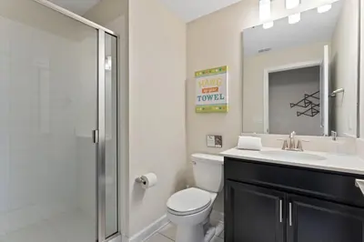 a bathroom with a toilet and a sink and a shower at Disney Getaway Private Pool Themed Bedrooms. Book Now SLR503 in Kissimmee