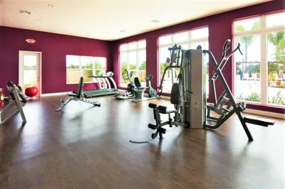 a gym with several treadmills and machines in a room at Disney Getaway Townhouse with Private Pool. Book Now WLV82 in Kissimmee