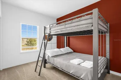 a bedroom with a bunk bed with an orange wall at Disney Getaway Townhouse with Private Pool. Book Now WLV82 in Kissimmee