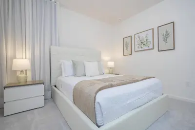 a white bedroom with a white bed and a nightstand at Disney Getaway Private Pool Themed Bedrooms. Book Now BV241 in Kissimmee