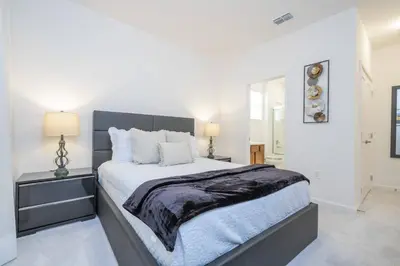 a bedroom with a large bed with white walls at Disney Getaway Private Pool Themed Bedrooms. Book Now BV241 in Kissimmee