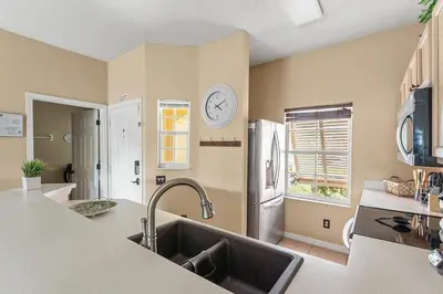 a kitchen with a sink and a white refrigerator at Disney Getaway Townhouse with Private Pool. Book Now EIR68 in Kissimmee