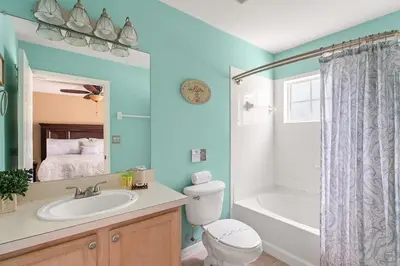a bathroom with a toilet and a tub and a sink at Disney Getaway Townhouse with Private Pool. Book Now EIR68 in Kissimmee