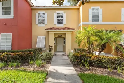 a house with a sidewalk in front of it at Disney Getaway Townhouse with Private Pool. Book Now EIR68 in Kissimmee