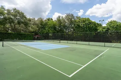 a tennis court with two tennis rackets on it at Disney Getaway Townhouse with Private Pool. Book Now EIR68 in Kissimmee