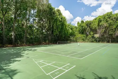 an empty tennis court with trees in the background at Disney Getaway Townhouse with Private Pool. Book Now EIR68 in Kissimmee