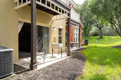 a patio of a house with a table and chairs at Disney Getaway Townhouse with Private Pool. Book Now EIR68 in Kissimmee